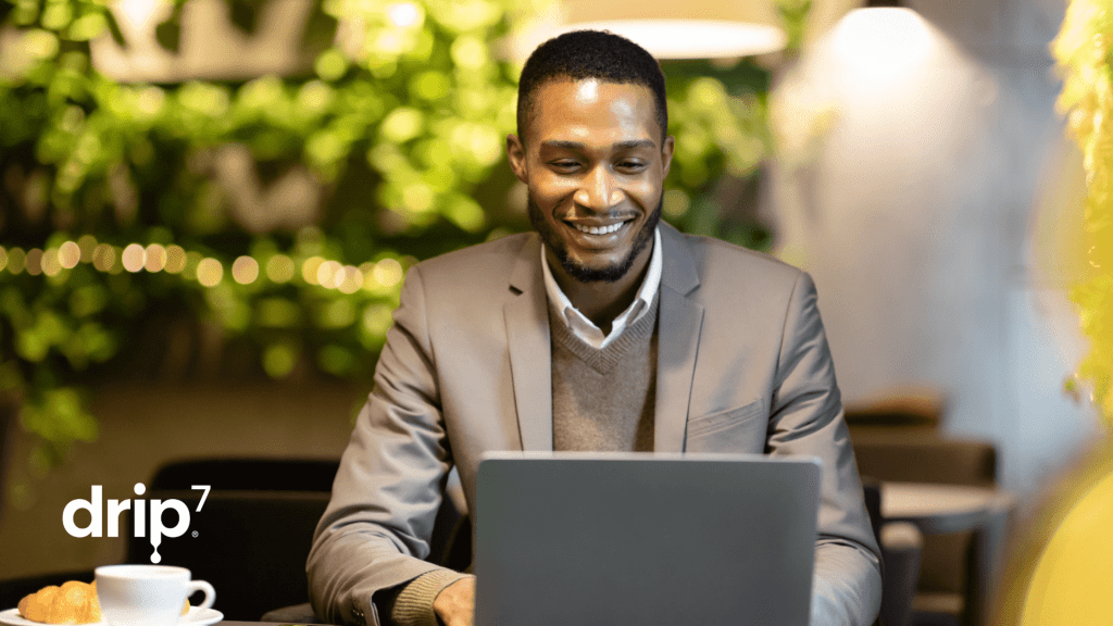 Man types on a laptop in a coffee shop. 